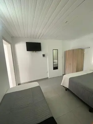 a bedroom with two beds and a flat screen tv at MIGUEL JUAREZ 47 in Villa Carlos Paz