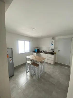 a kitchen with a wooden table and a counter top at MIGUEL JUAREZ 47 in Villa Carlos Paz