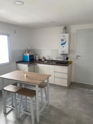 a kitchen with a wooden table and a table and chairs at MIGUEL JUAREZ 47 in Villa Carlos Paz