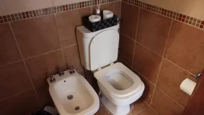 a bathroom with a toilet and a bidet at Casa con pileta en las sierras in La Calera