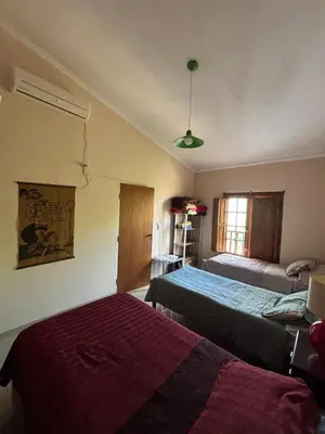 a bedroom with two beds and a window at Casa con pileta en las sierras in La Calera