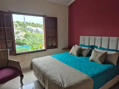a bedroom with a large bed and a window at Casa con pileta en las sierras in La Calera