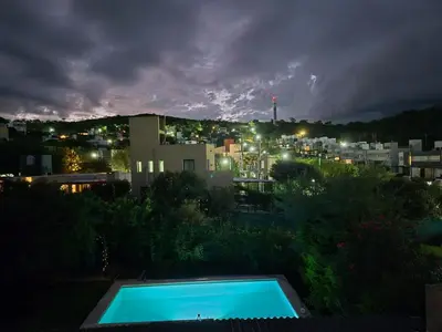 a view of a swimming pool at night at Casa con pileta en las sierras in La Calera