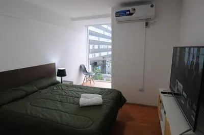 a bedroom with a green bed and a flat screen tv at Hermosa Vista 2 in Cordoba