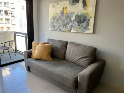 a brown couch in a living room with a painting at Departamento equipado ideal para 4 en Nueva Córdoba in Cordoba