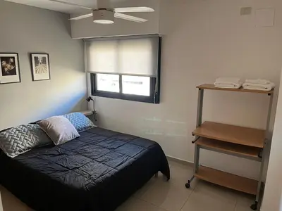 a bedroom with a bed and a window and a table at Departamento equipado ideal para 4 en Nueva Córdoba in Cordoba