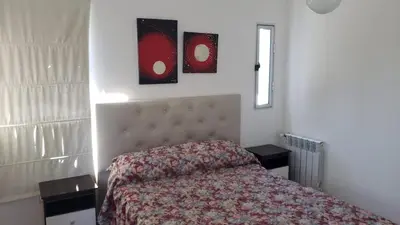 a bedroom with a bed and two tables and a window at Hermosa casa 351-6 en villa 157 carlos paz 157 - SOLO FAMILIAS in Villa Carlos Paz