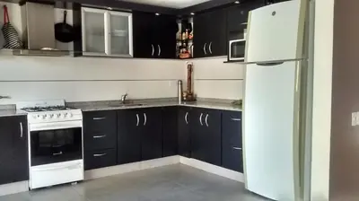 a kitchen with black cabinets and a white refrigerator at Hermosa casa 351-6 en villa 157 carlos paz 157 - SOLO FAMILIAS in Villa Carlos Paz