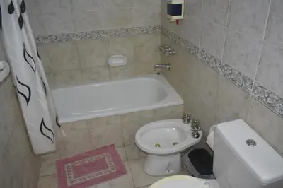 a bathroom with a tub and a toilet and a sink at Club Resort in Mina Clavero