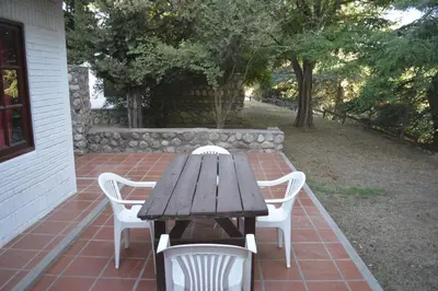a wooden table and chairs on a brick patio at Club Resort in Mina Clavero