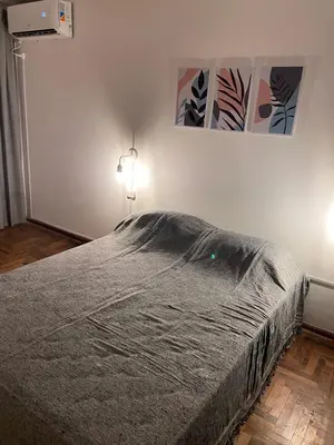 a bedroom with a bed and two lights on the wall at Rondeau Apartamento in Cordoba