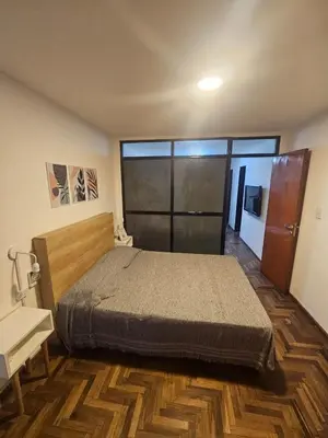 a bedroom with a bed and a wooden floor at Rondeau Apartamento in Cordoba