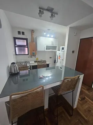 a kitchen with a table and two chairs in a room at Rondeau Apartamento in Cordoba