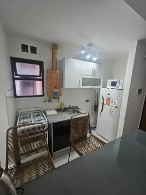a small kitchen with two chairs and a refrigerator at Rondeau Apartamento in Cordoba