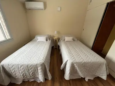 two beds in a small room with a table at Casa Cerro de las Rosas in Cordoba
