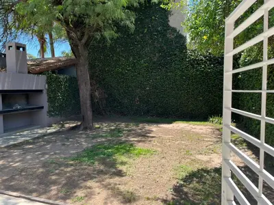 a fence next to a hedge with a tree at Casa Cerro de las Rosas in Cordoba