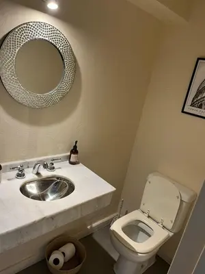 a bathroom with a sink and a toilet with a mirror at Casa Cerro de las Rosas in Cordoba