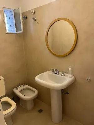 a bathroom with a sink and a toilet and a mirror at Casa Cerro de las Rosas in Cordoba