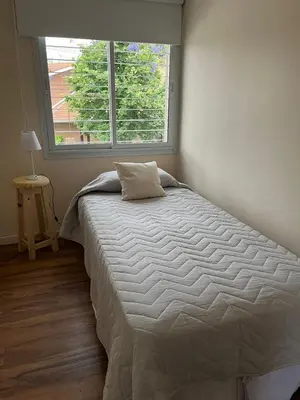 a bed in a bedroom with a large window at Casa Cerro de las Rosas in Cordoba