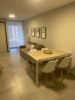 a living room with a table and a couch at Departamento -Cata- Pleno General Paz, cerca de Sanatorios, Terminal de omnibus y Nueva Cordoba, BY Apartcba in Cordoba