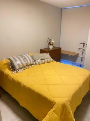 a large yellow bed in a room with a table at Departamento -Cata- Pleno General Paz, cerca de Sanatorios, Terminal de omnibus y Nueva Cordoba, BY Apartcba in Cordoba