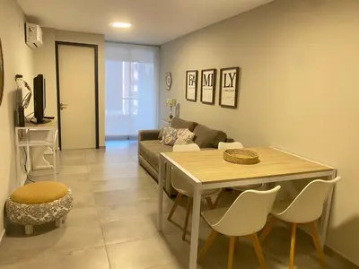 a living room with a table and a couch at Departamento -Cata- Pleno General Paz, cerca de Sanatorios, Terminal de omnibus y Nueva Cordoba, BY Apartcba in Cordoba