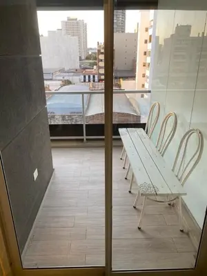 a table and chairs on a balcony with a window at Departamento -Cata- Pleno General Paz, cerca de Sanatorios, Terminal de omnibus y Nueva Cordoba, BY Apartcba in Cordoba