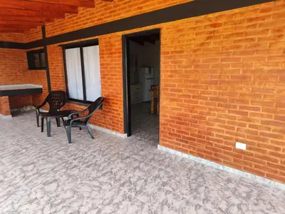 a patio with two chairs and a table next to a brick wall at Cabañas Alisha in Panaholma