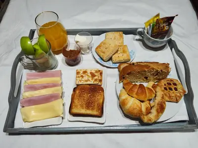 a tray filled with different types of bread and pastries at Cabañas Alisha in Panaholma