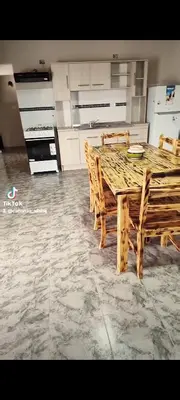 a kitchen with a wooden table and chairs at Cabañas Alisha in Panaholma
