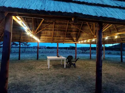 a table and a chair under a thatch roof at Cabañas Alisha in Panaholma