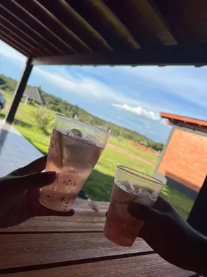 a person holding two drinks in their hands at Cabañas Alisha in Panaholma