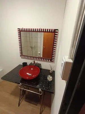 a bathroom with a red sink and a mirror at Casa Hebe - En las sierras de Córdoba - cuenta con tres habitaciones y capacidad para 8 personas, tranquila con increibles vistas in Villa Parque Siquiman