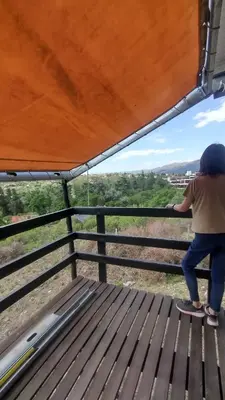 a person standing on a bench looking over a fence at Casa Hebe - En las sierras de Córdoba - cuenta con tres habitaciones y capacidad para 8 personas, tranquila con increibles vistas in Villa Parque Siquiman