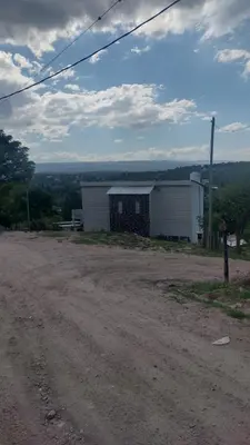 a dirt road with a building in the distance at Casa Hebe - En las sierras de Córdoba - cuenta con tres habitaciones y capacidad para 8 personas, tranquila con increibles vistas in Villa Parque Siquiman