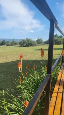 a view of a fence with flowers in a field at Cabaña Troncos en Los Reartes in Villa General Belgrano