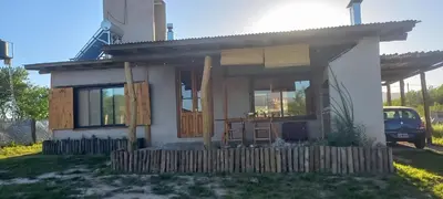 a small house with a porch and a fence at La adorable in Los Reartes