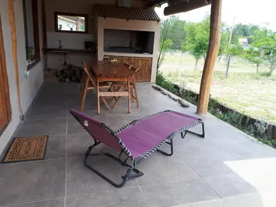 a porch with a table and a bench on a patio at La adorable in Los Reartes