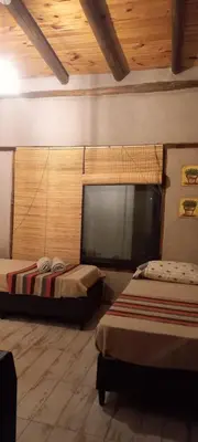 a room with two beds and a flat screen tv at La adorable in Los Reartes