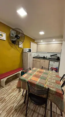 a room with a table and a kitchen with a fan at Cabaña Concepcion del Valle in Salsacate