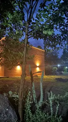a tree in front of a building at night at Cabaña Concepcion del Valle in Salsacate