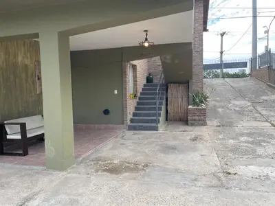 a house with a staircase and a couch on the porch at lahabanadepartamento in Villa Carlos Paz