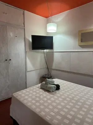 a bedroom with a bed with a tv on the wall at lahabanadepartamento in Villa Carlos Paz