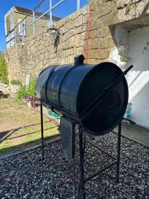 a black bbq grill sitting on top of gravel at lahabanadepartamento in Villa Carlos Paz