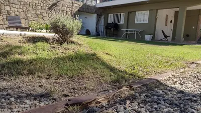 a backyard with a lawn and a house at lahabanadepartamento in Villa Carlos Paz