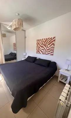 a bedroom with a large bed and a mirror at Depto Sorrento céntrico in Villa Carlos Paz