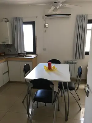 a kitchen with a table with chairs and a cup on it at Depto Sorrento céntrico in Villa Carlos Paz
