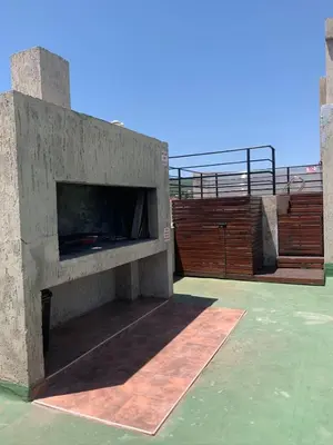 a large stone fireplace on top of a patio at Depto Sorrento céntrico in Villa Carlos Paz