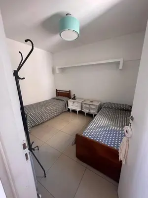 a bedroom with two beds and a light on the ceiling at Depto Sorrento céntrico in Villa Carlos Paz