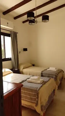 a bedroom with two beds and a window at Ribera Sur Hotel - Los Algarrobos - Tanti in Tanti